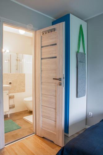 a bedroom with a door to a bathroom with a toilet at Dom przy borowinie in Kołobrzeg