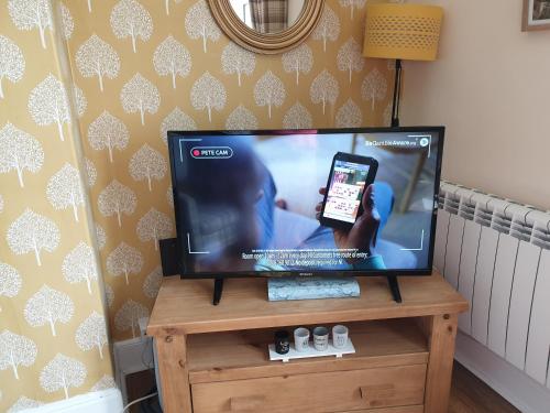 a flat screen tv sitting on top of a wooden stand at Millie's place in Fort William