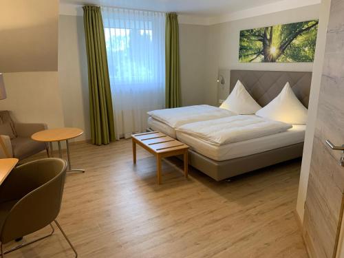 a hotel room with a bed and a table at Hotel-Restaurant Haus Waldesruh in Borken