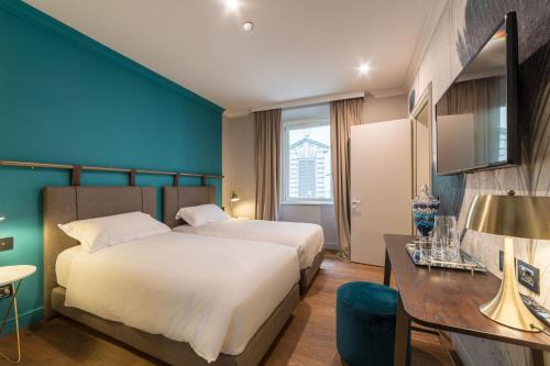 a hotel room with a bed and a desk at Palazzo 42 - Boutique Hotel & Suites in Pistoia