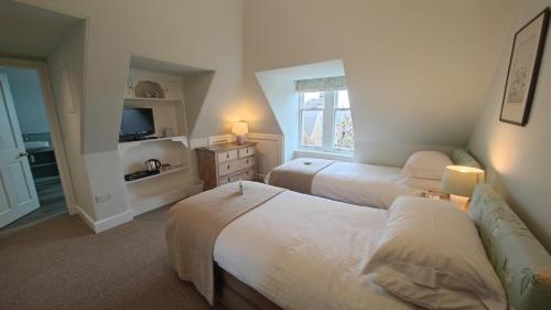 a bedroom with two beds and a television in it at Glengair in North Berwick