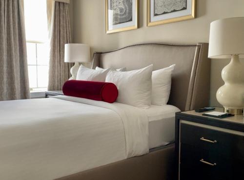 a white bed with a white comforter next to a window at Henley Park Hotel in Washington, D.C.