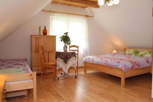 a bedroom with two beds and a table and a chair at Zamsówka in Guciów