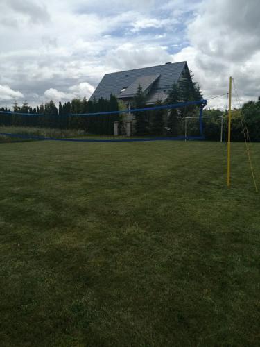 a soccer goal in a field with a building at Zielone Tarasy na Kaszubach in Sikorzyno