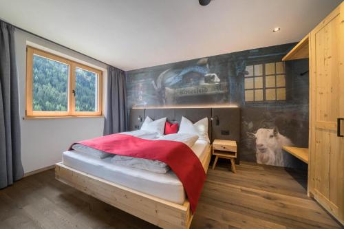 een slaapkamer met een bed en een muurschildering van een koe bij Seebrunn - Kaserfeld Alm in Ultimo