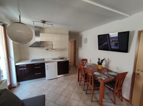 Apartments Bohinjc في بوينج: مطبخ وغرفة طعام مع طاولة وكراسي