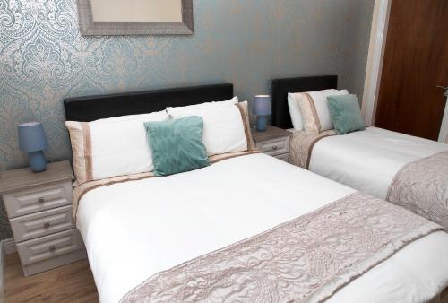 two twin beds in a room with blue walls at Arch House B&B & Apartments in Athlone