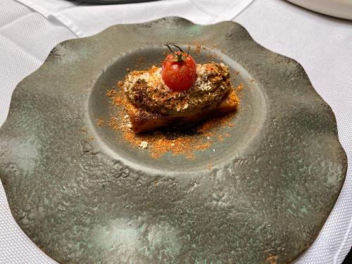 a plate of food with a tomato on it at Albergo Wellness Da Febo in Tramonti di Sotto