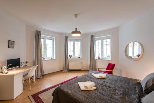 1 dormitorio con 1 cama, escritorio y ventanas en Apartment CHOPIN en Mariánské Lázně