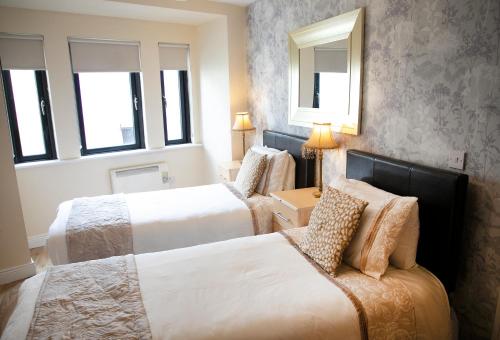a hotel room with two beds and a mirror at Arch House B&B & Apartments in Athlone