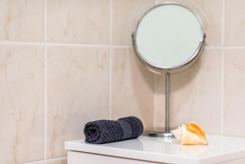 a mirror sitting on top of a white table with a towel at Apartment CHOPIN in Mariánské Lázně