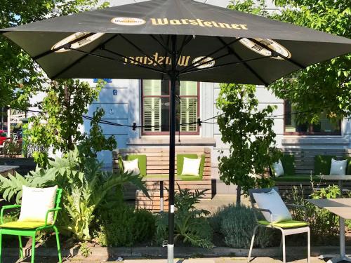 a black umbrella with two chairs and a table at Suitehotel Pincoffs in Rotterdam