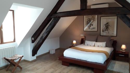 a bedroom with a large bed in a attic at La Merlette89 in Lailly