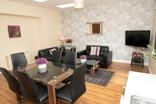 a living room with a table and chairs and a tv at Arch House B&B & Apartments in Athlone
