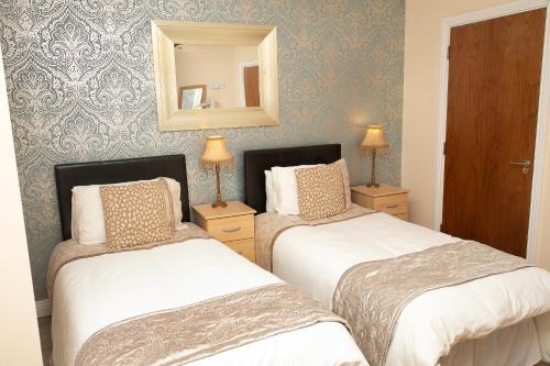 a bedroom with two beds and a mirror at Arch House B&B & Apartments in Athlone