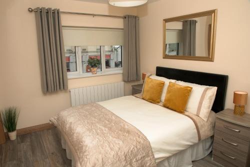 a bedroom with a bed with yellow pillows and a mirror at Arch House B&B & Apartments in Athlone