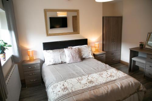 a bedroom with a bed with two night stands and a mirror at Arch House B&B & Apartments in Athlone