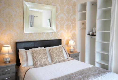 a bedroom with a bed with a mirror and shelves at Arch House B&B & Apartments in Athlone