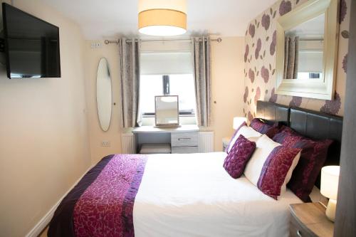 a bedroom with a white bed and a television at Arch House B&B & Apartments in Athlone