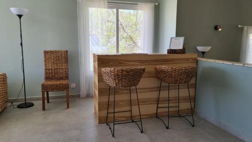 a bar with two stools and a counter with a window at Olives in Arad