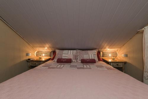 - un grand lit dans une petite chambre avec deux lampes dans l'établissement Doce Lar Hostel Noronha, à Fernando de Noronha