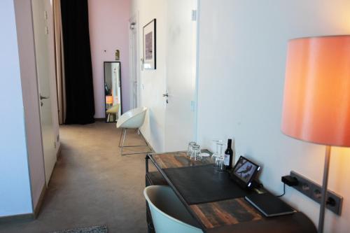 a room with a desk and a table and chairs at Suitehotel Pincoffs in Rotterdam