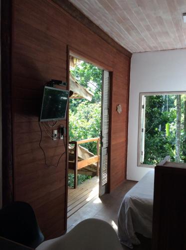 Schlafzimmer mit einem Bett und einem Fenster mit einem Balkon in der Unterkunft Casa Grande Flats in Abraão