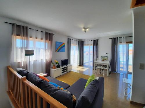a living room with a blue couch and a table at Sunflower Sea View with magnificent terrace in Serra da Pescaria, Nazaré - Portugal in Nazaré