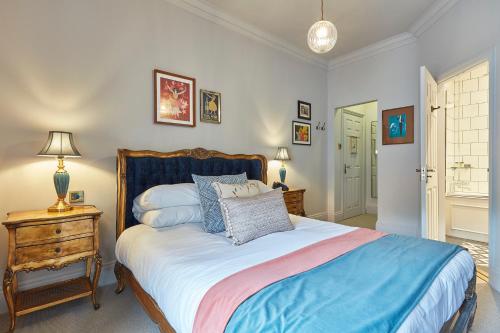 a bedroom with a bed and a table with a lamp at The Hoste and The Vine House Hotels in Burnham Market
