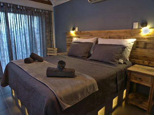 聖赫勒拿灣的住宿－Onze Uitsight Cottage，一间卧室配有一张大床和木制床头板