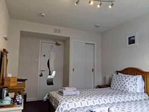 a bedroom with two beds and a door with a mirror at Rockvilla Guest House in Lochcarron