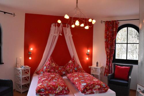 um quarto com paredes vermelhas e uma cama com almofadas vermelhas em Gastinger Hotel-Restaurant em Schmiedefeld am Rennsteig