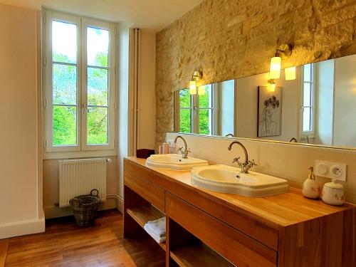 a bathroom with two sinks and a large mirror at Le Moulin Neuf in Ancy-le-Franc