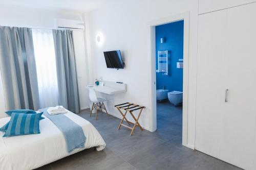 a bedroom with a bed and a bathroom with a sink at B&B a due passi dal mare in Gela