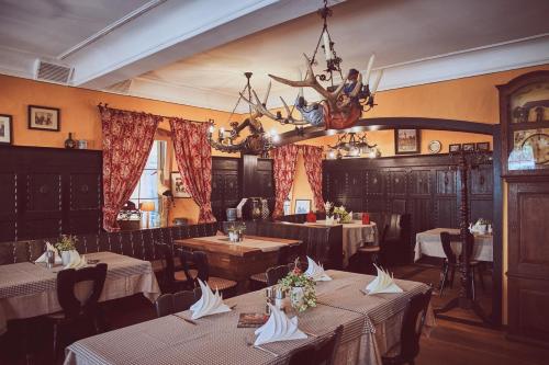 ein Restaurant mit Tischen, Stühlen und einem Kronleuchter in der Unterkunft Gasthof zum Storch in Prichsenstadt