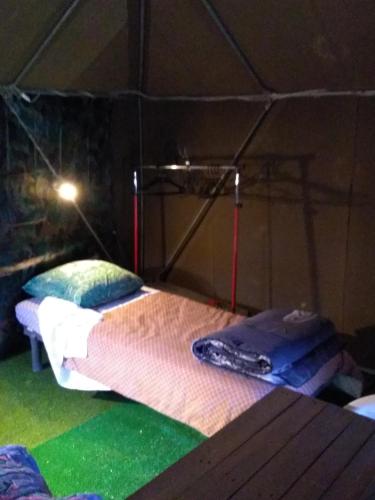 une chambre avec un lit dans une tente dans l'établissement la tente du commandant français 1954 pour nuit insolite, à Arrest