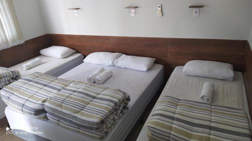 Rúm í herbergi á Pousada Quarto Familiar com ar,frigobar,wi fi, garagem