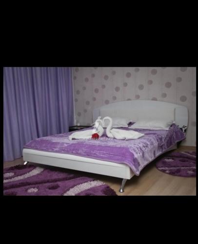 a bed with a stuffed animal sitting on top of it at Vila Eduard in Mamaia Sat/Năvodari