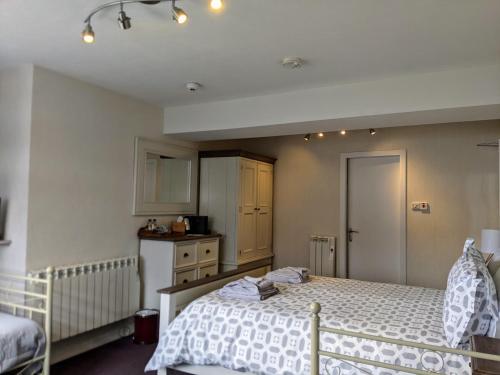 a bedroom with two beds and a kitchen at Rockvilla Guest House in Lochcarron