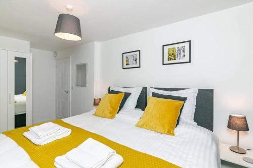 a bedroom with a large bed with yellow pillows at Cunningham Lodge in Hatfield