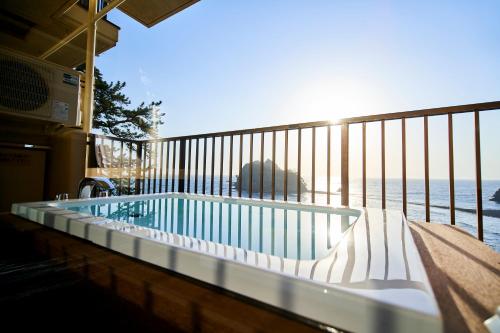 a swimming pool on a balcony with a view of the ocean at il azzurri in Nishiizu