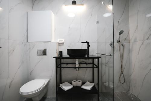 een witte badkamer met een toilet en een douche bij Unique Hotel Ashdod in Ashdod