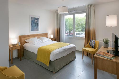 um quarto com uma cama, uma secretária e uma janela em DOMITYS LA BADIANE em Marselha
