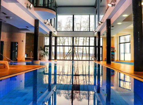 a large swimming pool with blue tiles in a building at Hotel Ukiel Wellness & SPA in Olsztyn