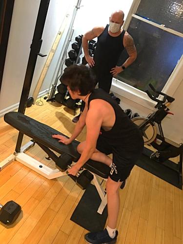 two people in a gym with a woman on a treadmill at Love-nest With Private Hot Tub in Toronto