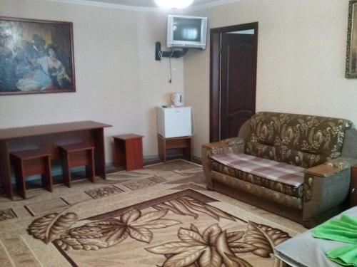 a living room with a couch and a table at Kak v gostinice in Hadyach