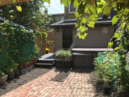 a garden with a brick patio and plants at Love-nest With Private Hot Tub in Toronto