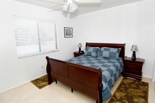 Schlafzimmer mit einem Bett und einem Deckenventilator in der Unterkunft Lilsis by the Lake in Port Charlotte