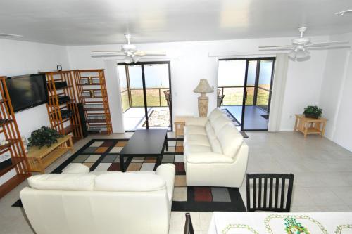 a living room with white couches and a tv at Lilsis by the Lake in Port Charlotte