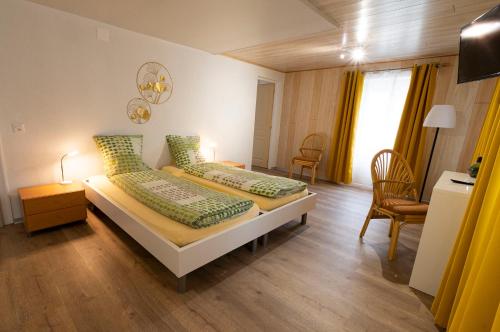 a bedroom with two beds with green pillows at Hôtel Bellavista "Bellevue" in Saignelégier